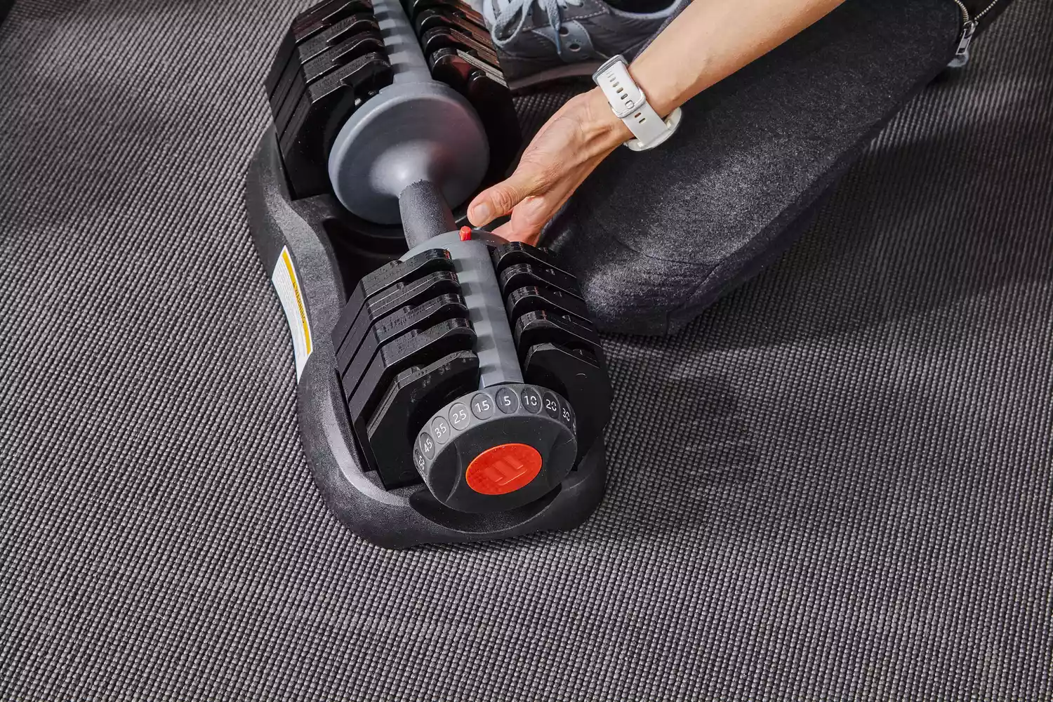 Hand holding ETHOS 50 lb. Selectable Dumbbell