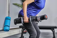 Person lifting ETHOS 50 lb. Selectable Dumbbells