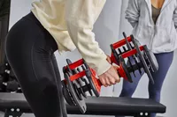 Person lifting FitRx SmartBells Set Quick Select Adjustable Dumbbells
