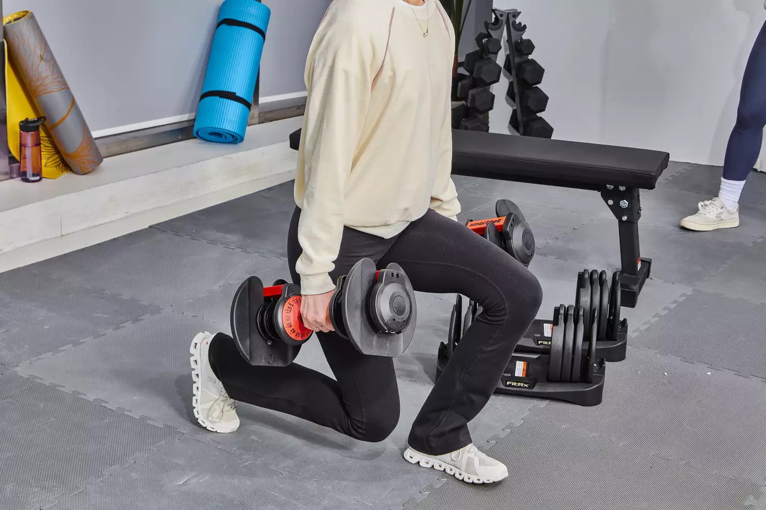 Person doing lunges with FitRx SmartBells Set Quick Select Adjustable Dumbbells