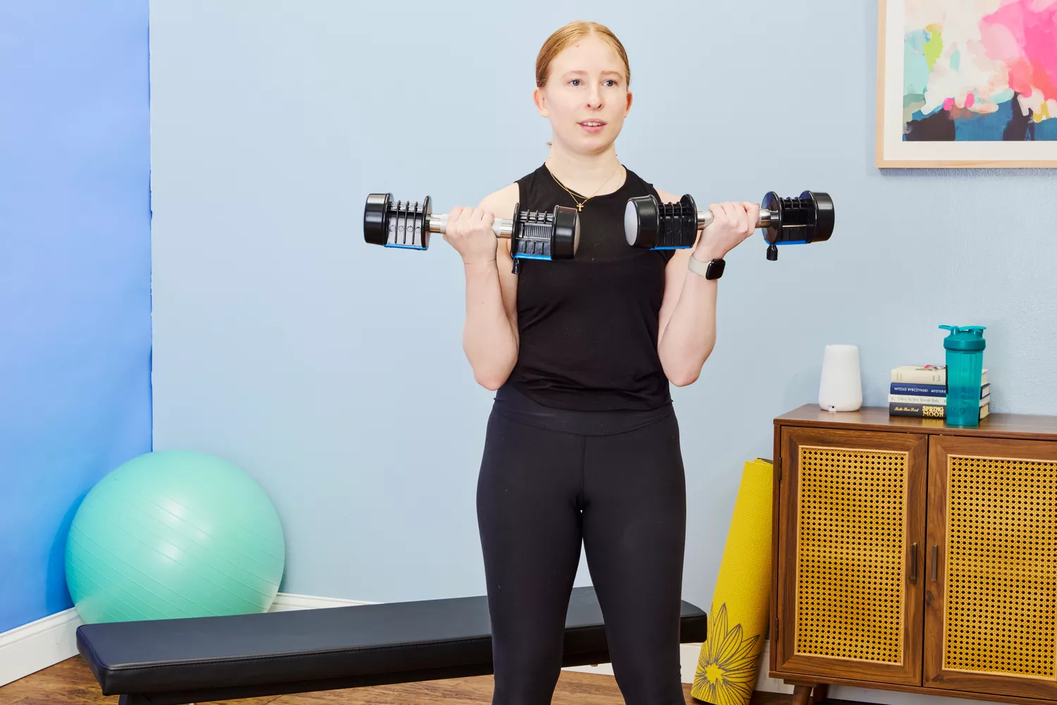 A person does arm curls using the Lifepro PowerFlow Plus Adjustable Dumbbell Set