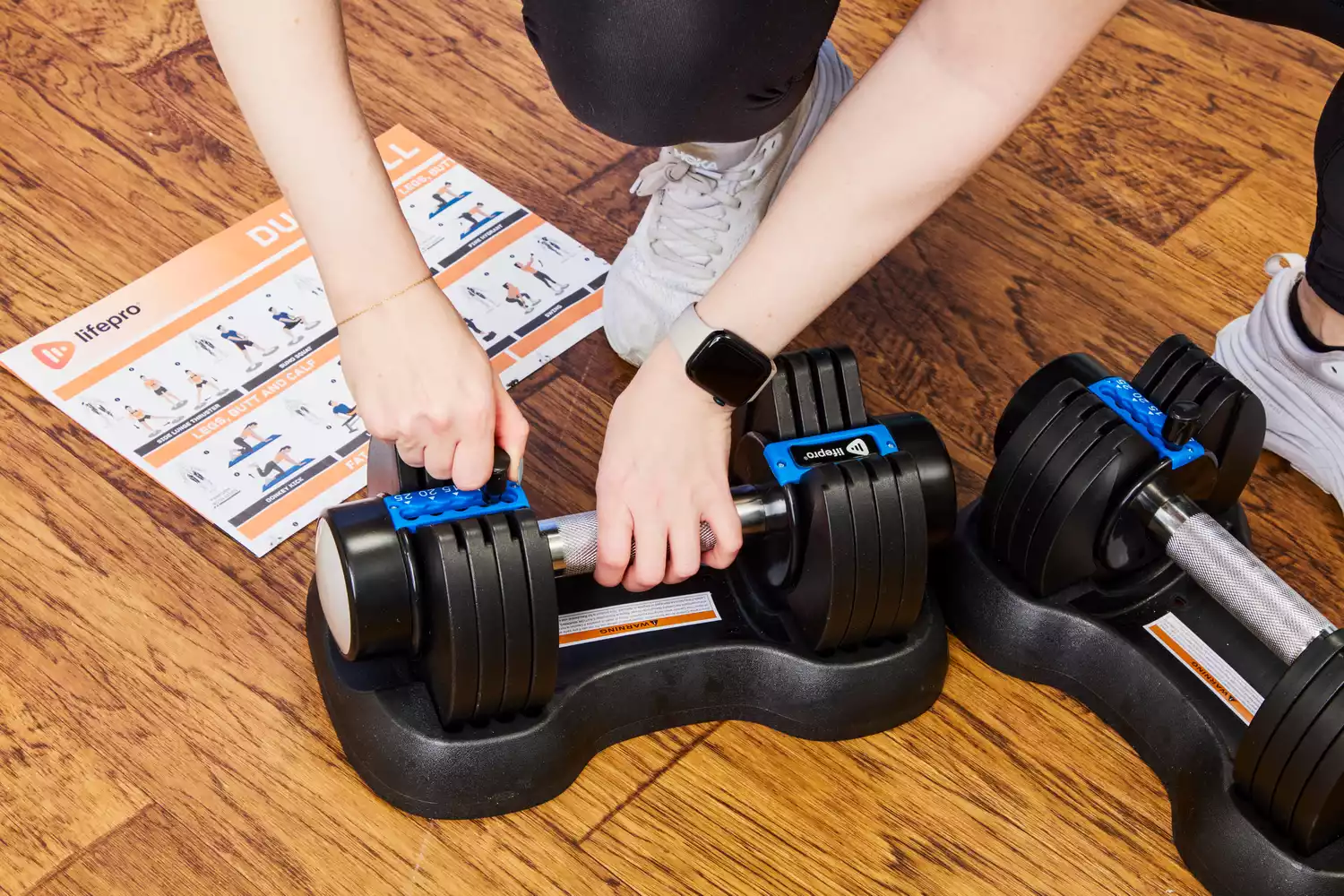 A person adjusts the weight on the Lifepro PowerFlow Plus Adjustable Dumbbell Set