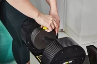 Hand adding weight to a MX55 Rapid Change Adjustable Dumbbell