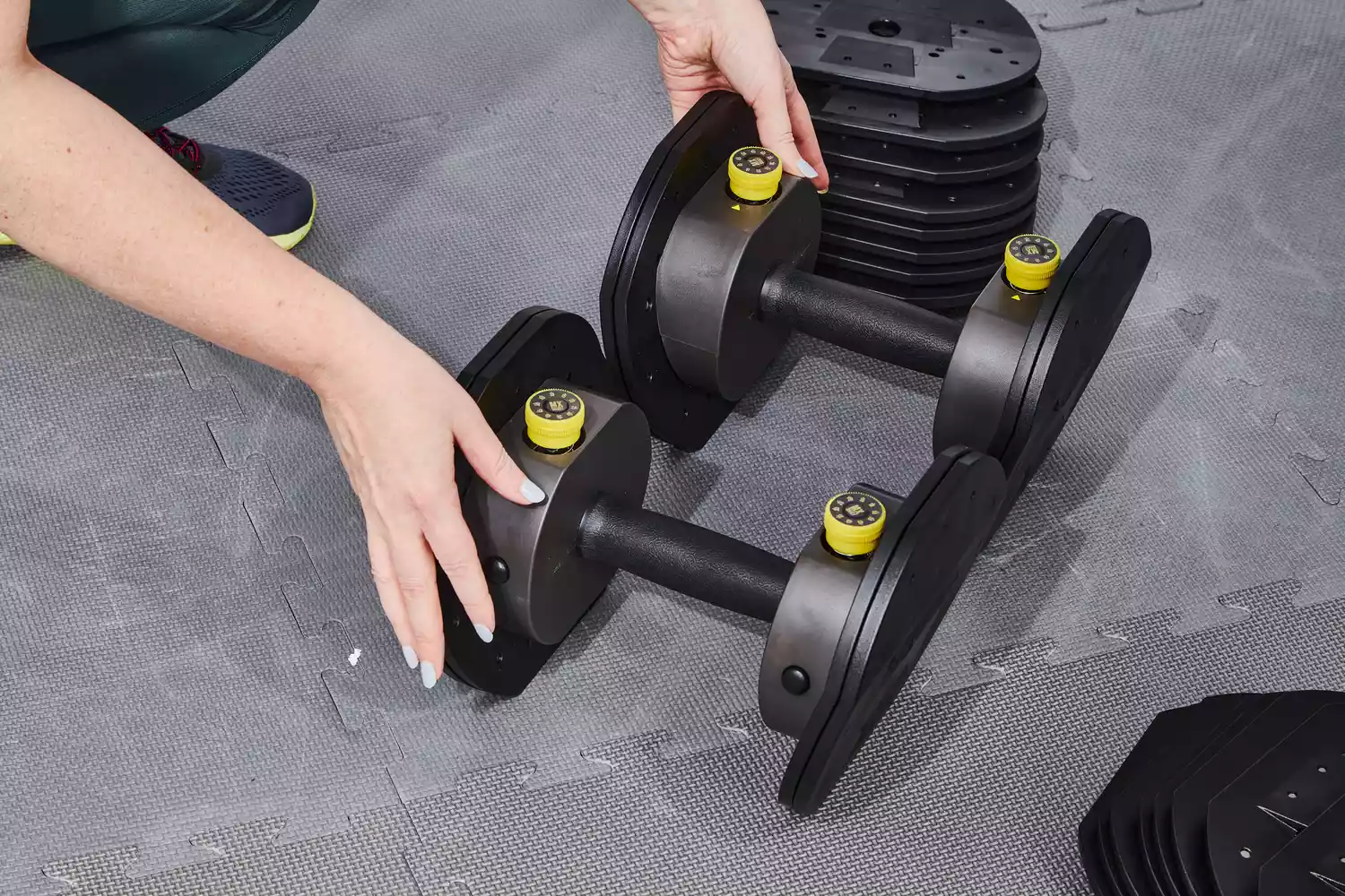 Hands touching the MX55 Rapid Change Adjustable Dumbbells 