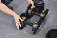 Hands touching the MX55 Rapid Change Adjustable Dumbbells 