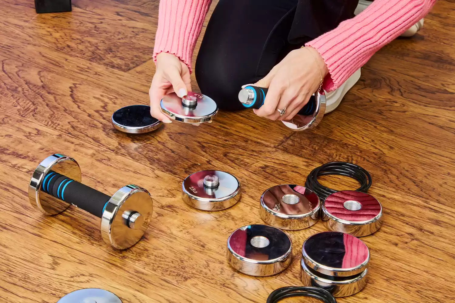 A person assembles the Northdeer Steel Dumbbells Ultracompact & Adjustable Chrome Dumbbells
