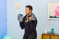 A person does arm curls using the POWERBLOCK Elite EXP Adjustable Dumbbells