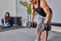 Person lifting ProForm Select-a-Weight Dumbbells