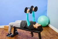 A person lifts the Rep Fitness Quickdraw Adjustable Dumbbells