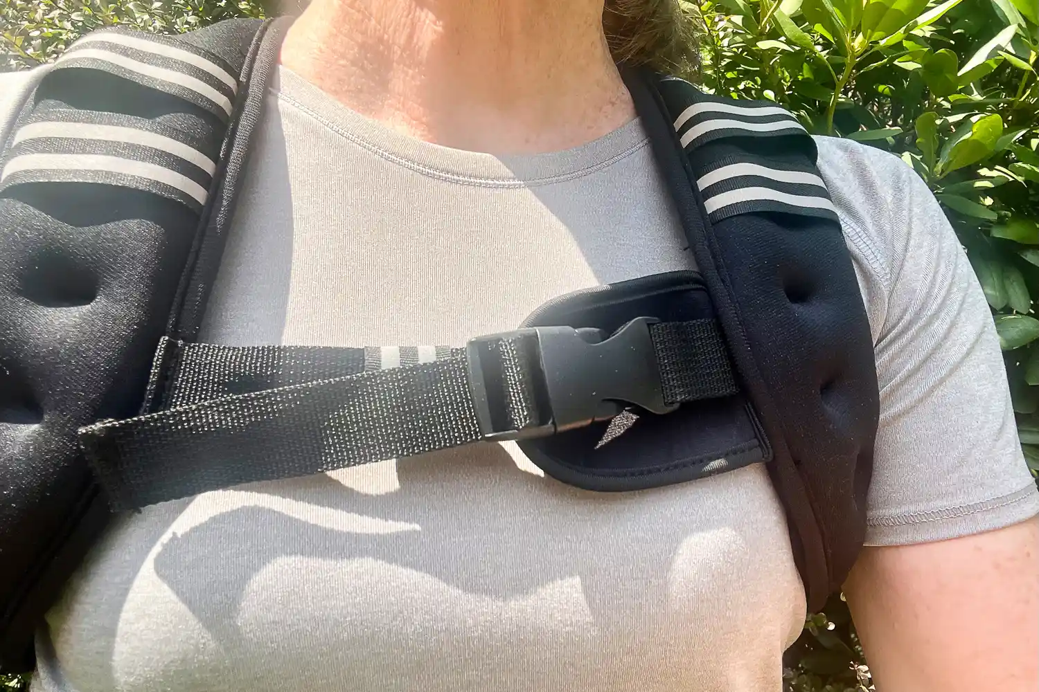 Person wearing a Aduro Sport Adjustable Weighted Vest with straps and a buckle