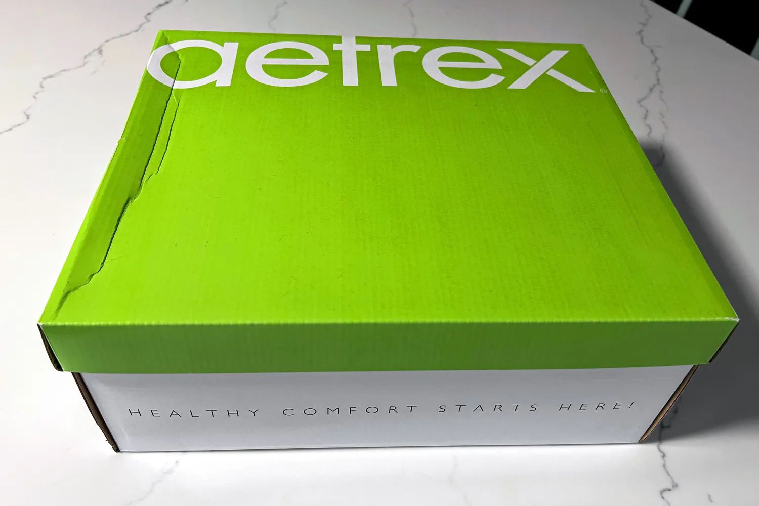 A green Aetrex Chase Arch Support Sneakers shoebox with the slogan 'Healthy Comfort Starts Here' on the side