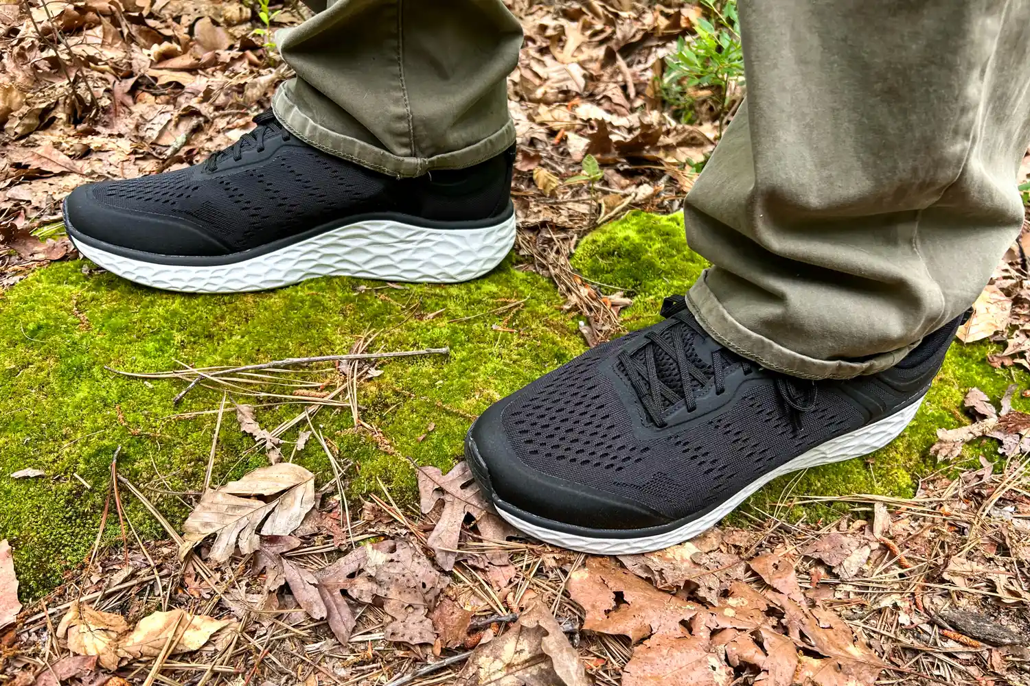 A person wearing Aetrex Chase Arch Support Sneakers standing on moss in a forest setting
