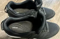 A pair of Aetrex Chase Arch Support Sneakers on a smooth wooden surface