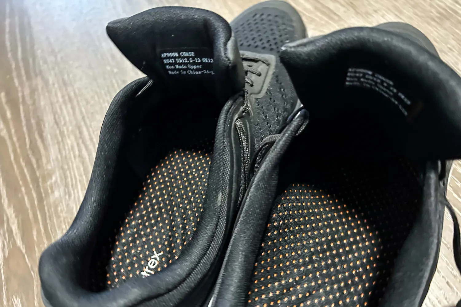 The inside of a pair of Aetrex Chase Arch Support Sneakers showing detailed tag information and dot-patterned inner soles