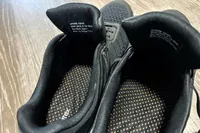 The inside of a pair of Aetrex Chase Arch Support Sneakers showing detailed tag information and dot-patterned inner soles