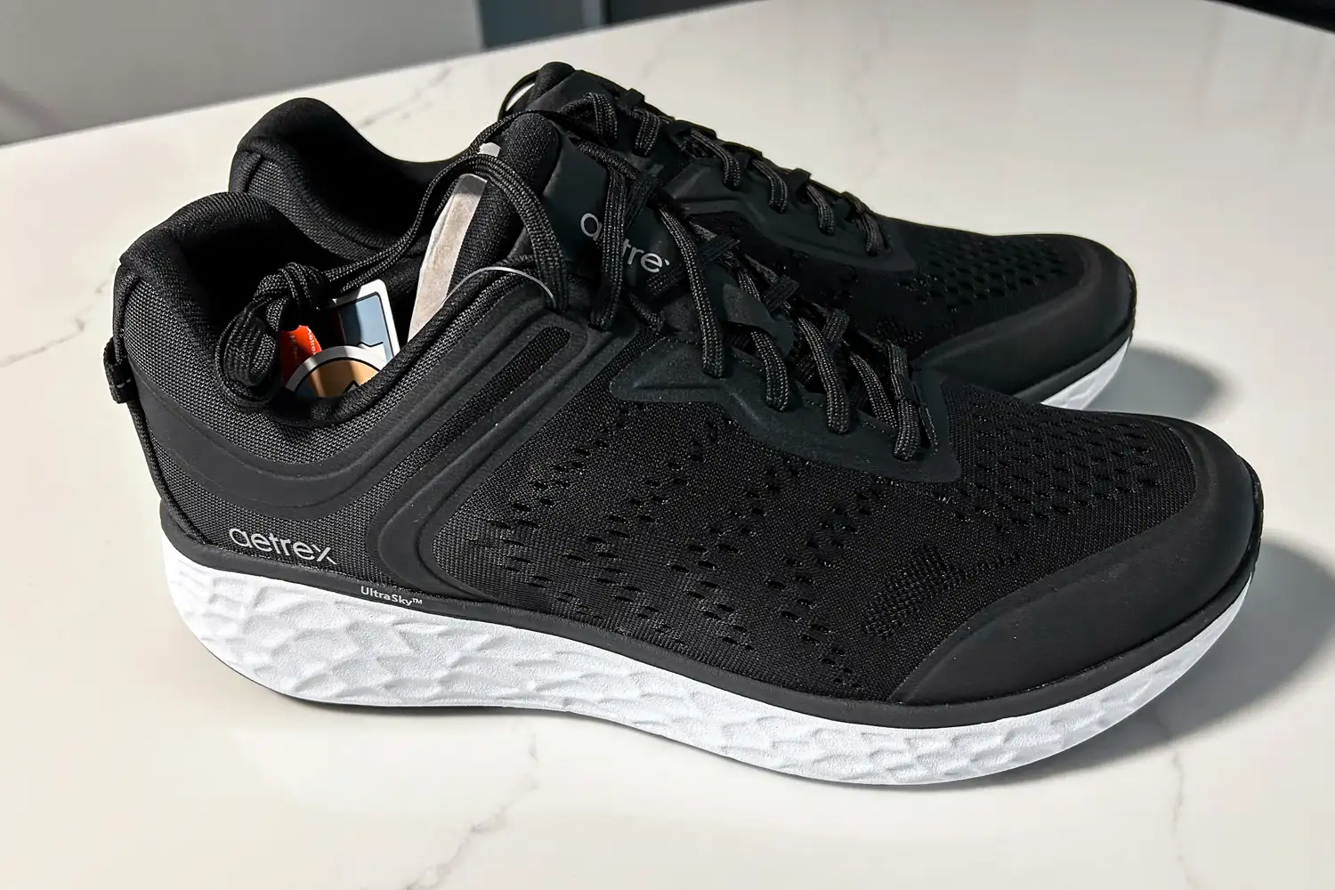 A pair of Aetrex Chase Arch Support Sneakers on a white surface