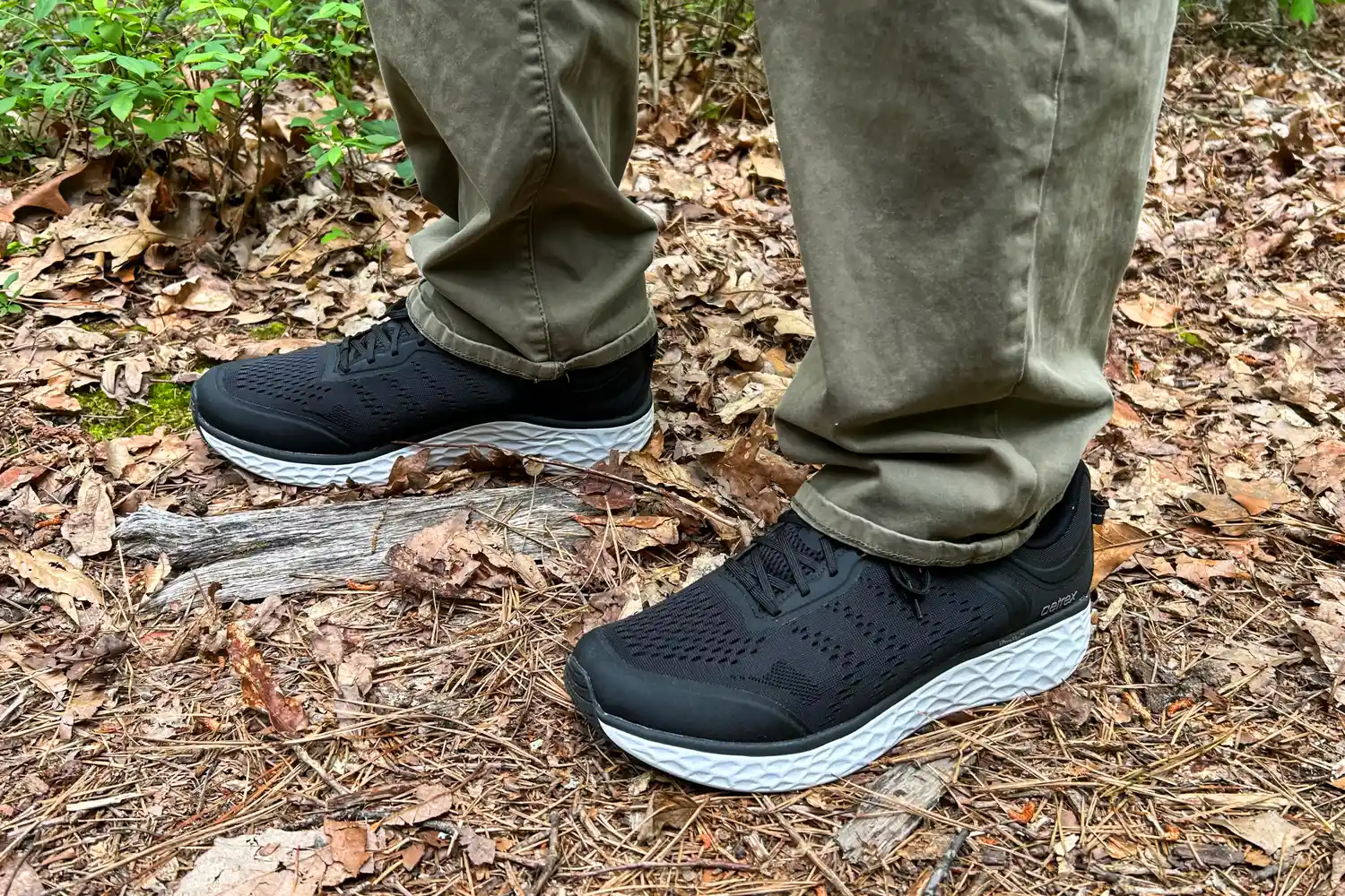 A person wearing Aetrex Chase Arch Support Sneakers standing on a forest floor