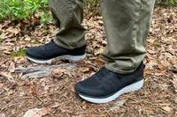 A person wearing Aetrex Chase Arch Support Sneakers standing on a forest floor