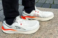 A person wearing Altra Men's Paradigm 7 Sneakers standing on a stone surface