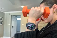 A person wears the Amazfit Bip 6 Smartwatch while lifting weights