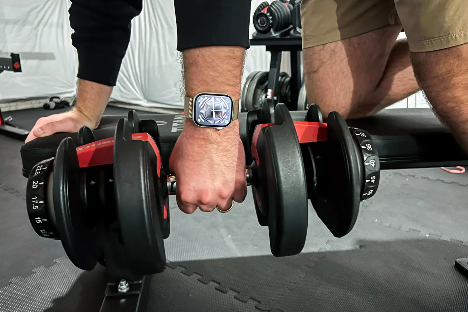 A person lifts weights while wearing the Apple Watch Series 10