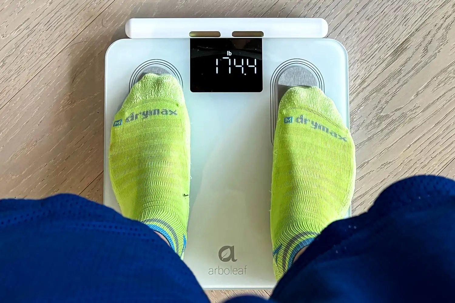 A person stands on the Arboleaf CS10E Segmental Body Scale in socks