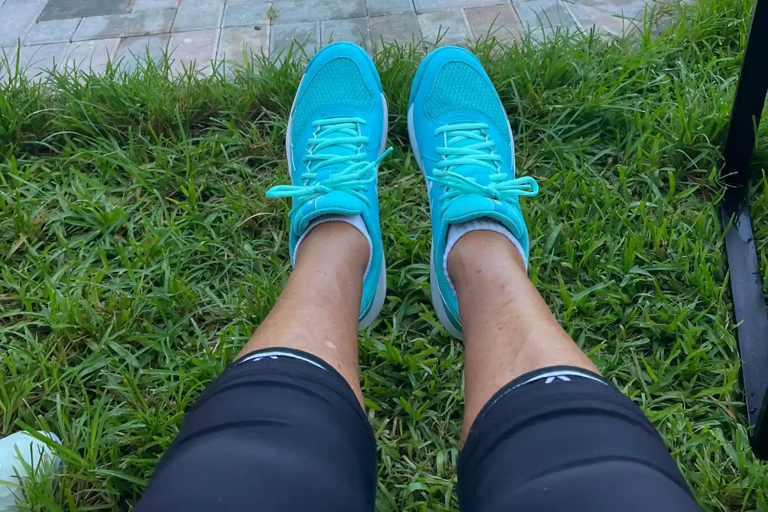 A person sits outside while wearing the Asics Women's Gel-Dedicate 8 Pickleball Shoes