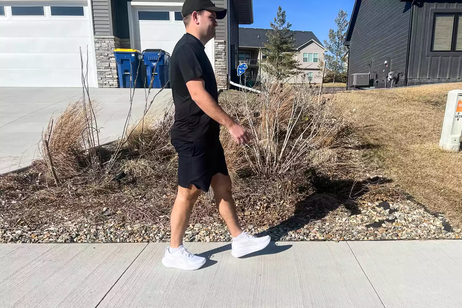 A person walking on a sidewalk while wearing the Asics Men's GEL-NIMBUS 27
