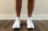 The Asics Men's GEL-NIMBUS 27 worn on a wooden floor