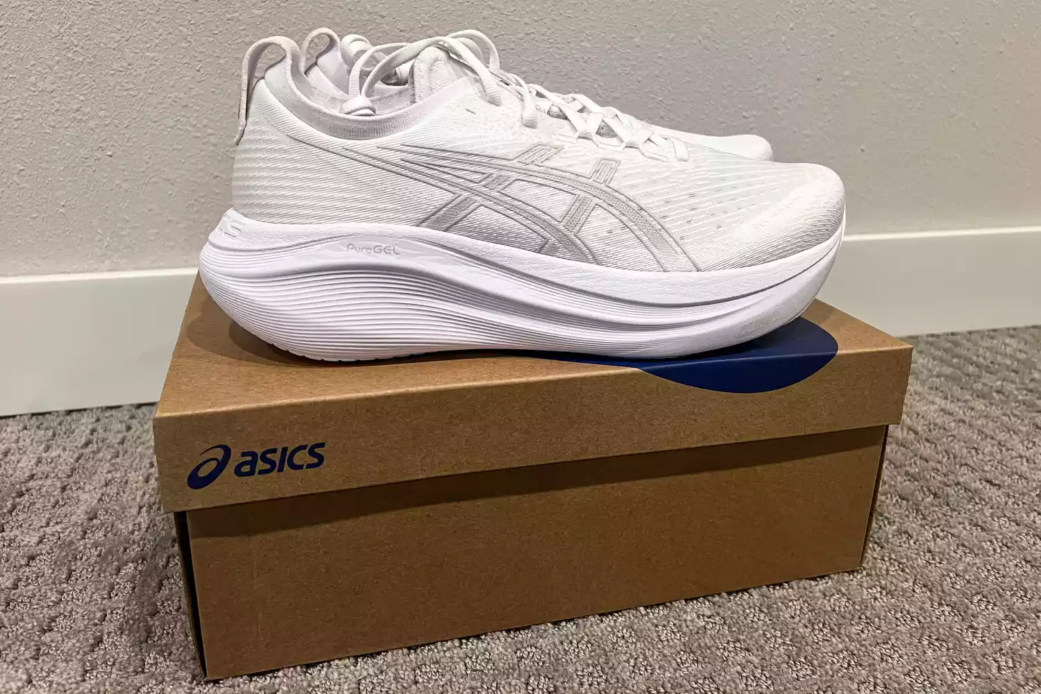 The Asics Men's GEL-NIMBUS 27 sneakers posed on their box
