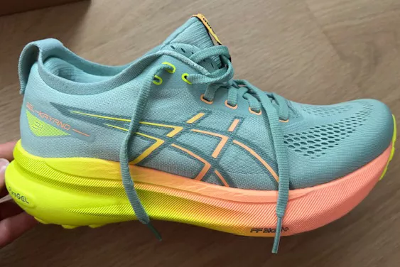 Person looking at Asics Gel-Kayano 31 placed on table