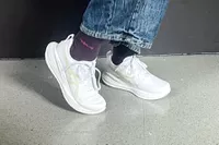 A person walks on tile while wearing the Asics Women's Gel-Cumulus 27 Running Shoes