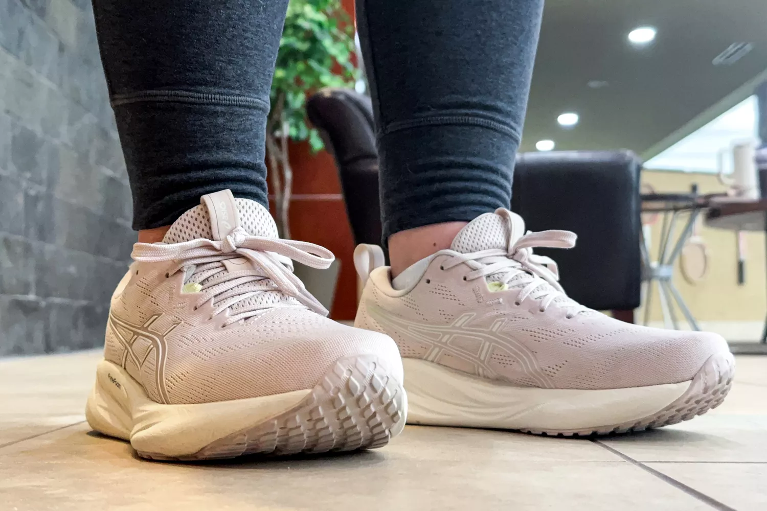 A close-up of the Asics Women's GEL-Pulse 16 sneakers worn on tile