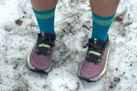 A person wears the Asics Women's Gel-Trabuco 13 Trail Running Sneakers in the snow