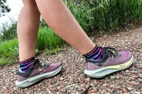A person walking on a trail wearing Asics Women's Gel-Trabuco 13 Trail Running Sneakers