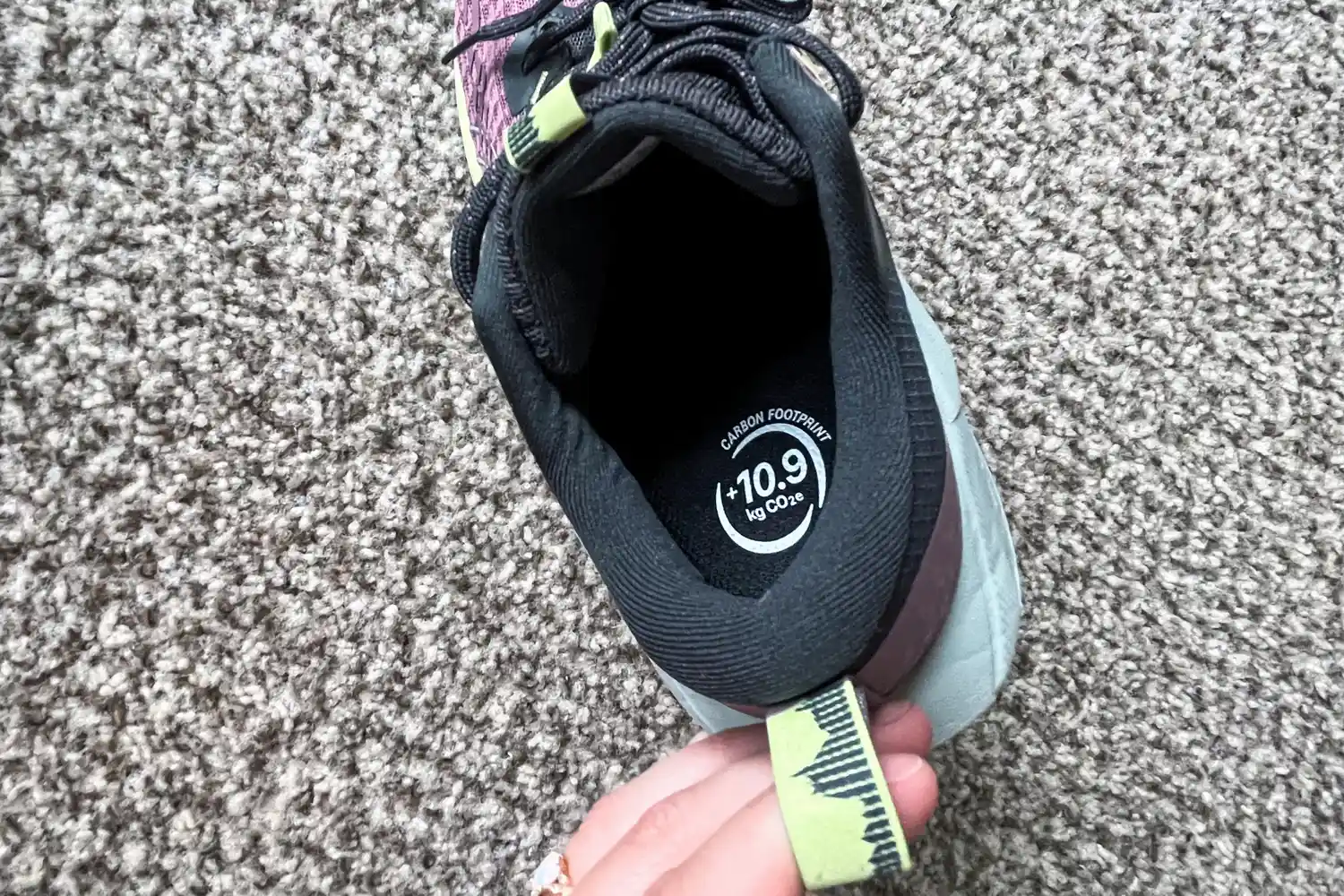 A person pulls the tab on the back of the Asics Women's Gel-Trabuco 13 Trail Running Sneaker