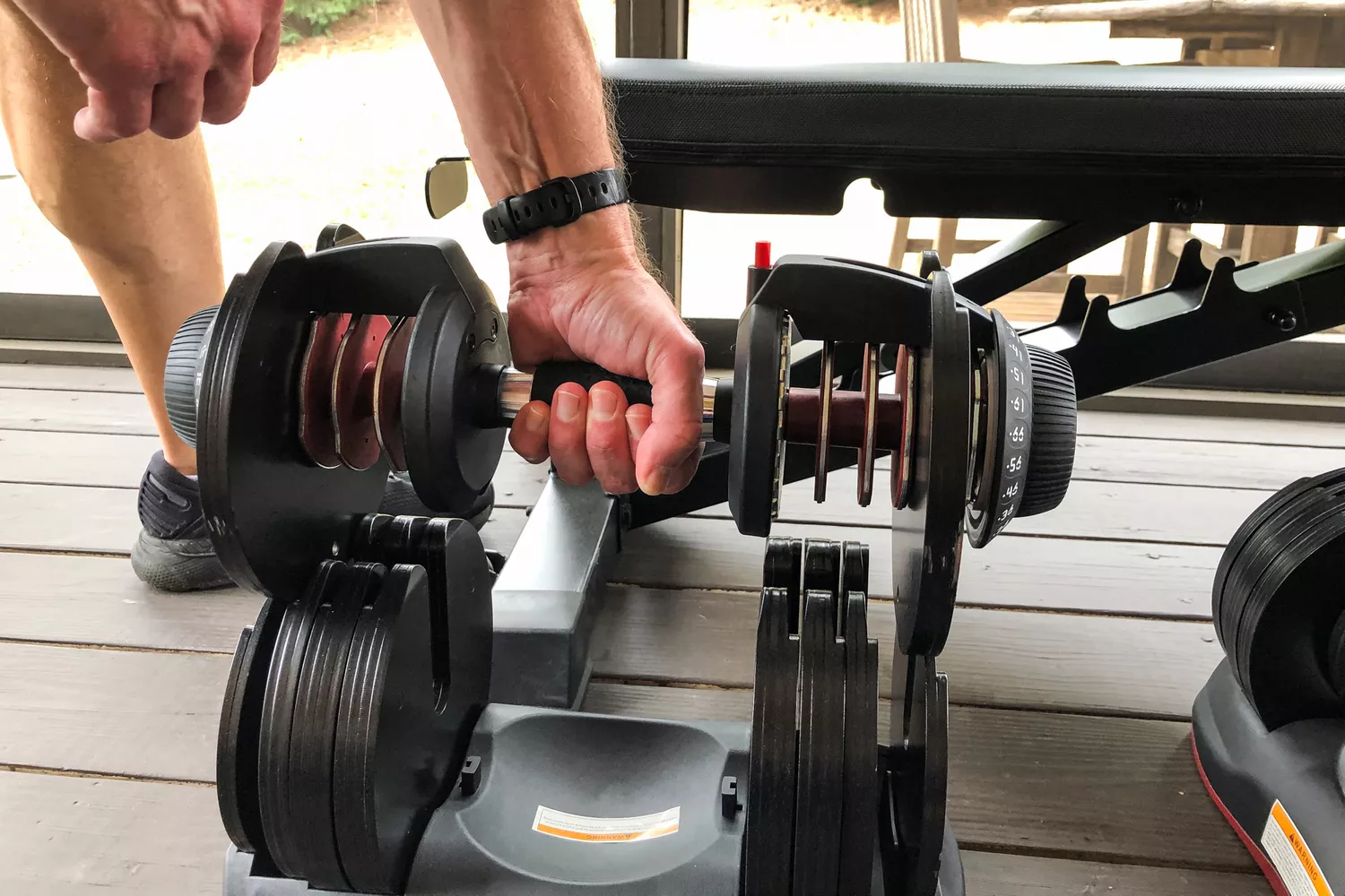 A person lifts the Ativafit Adjustable Dumbbell Set