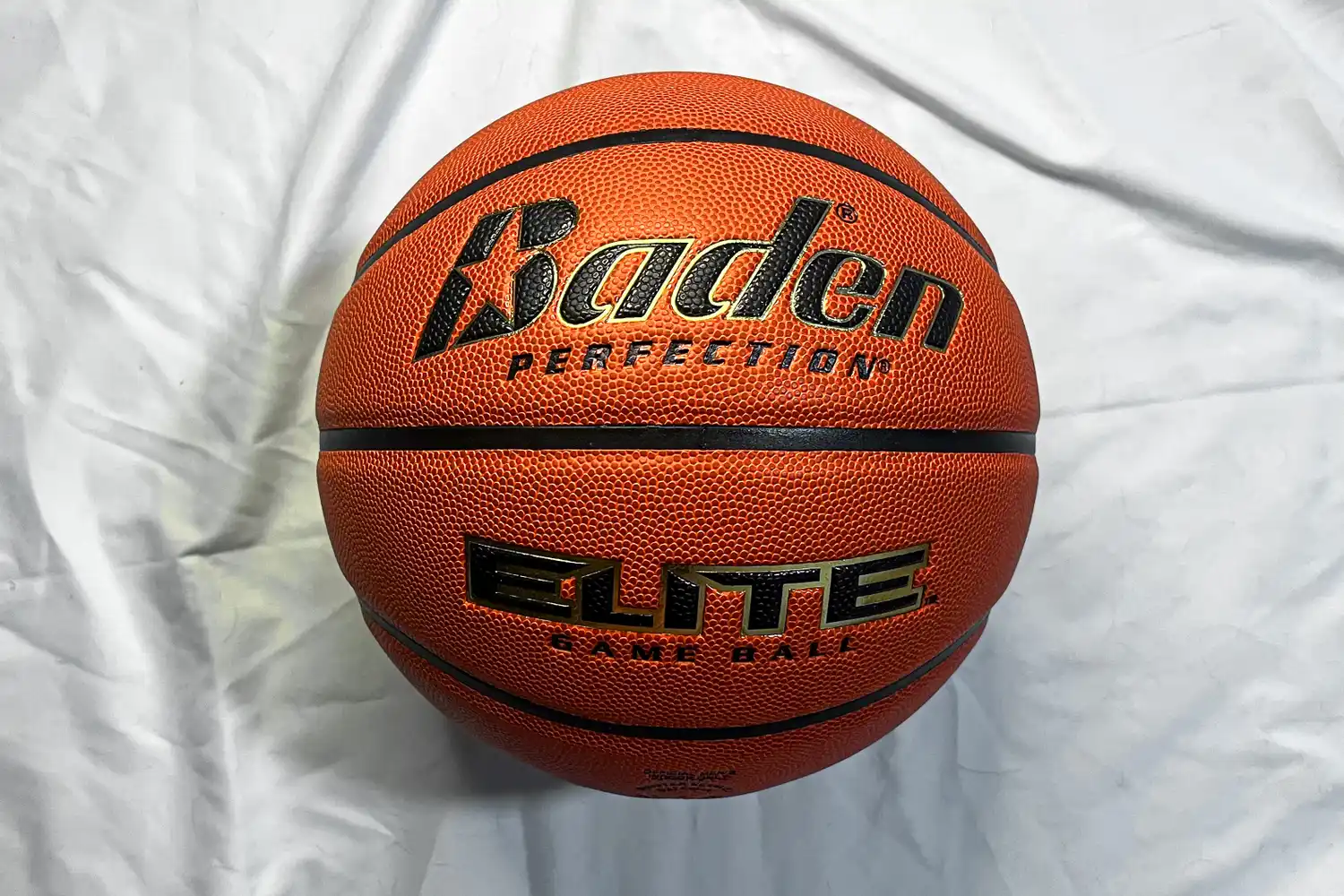 The Baden Elite Game Basketball on a bed