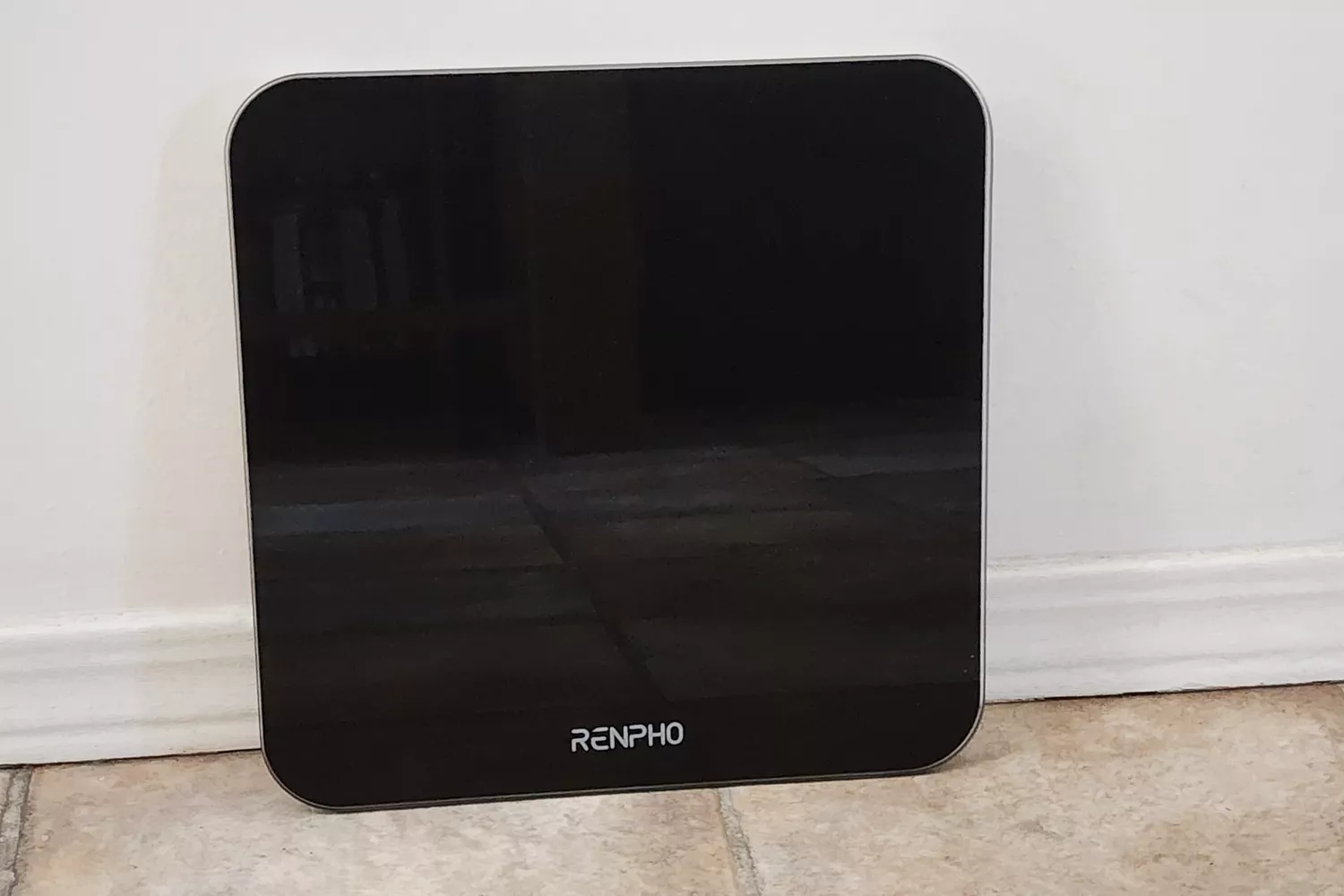 The Renpho Core 1S Body Scale leans on a wall