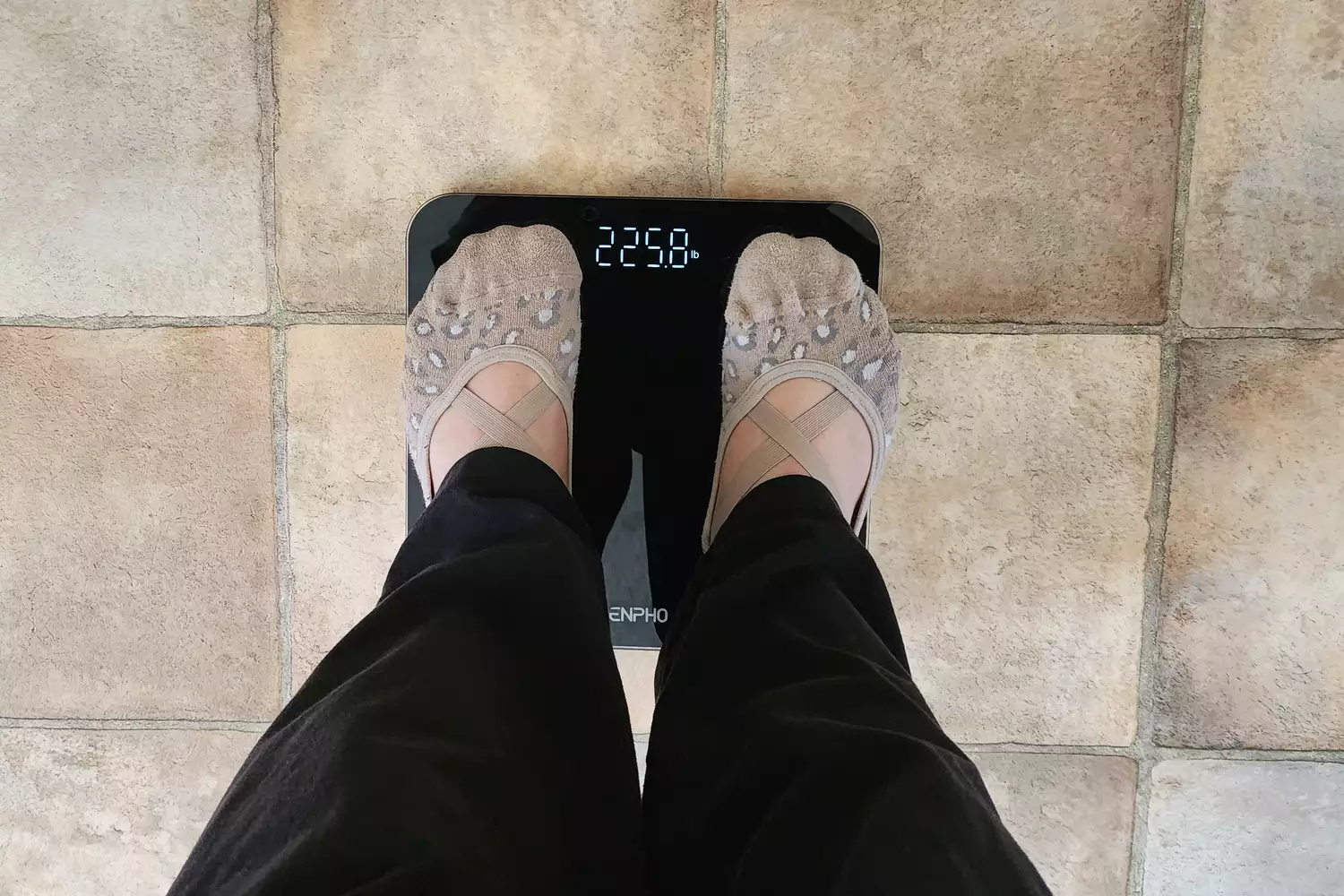 socked feet on the Renpho Core 1S Body Scale with weight displayed