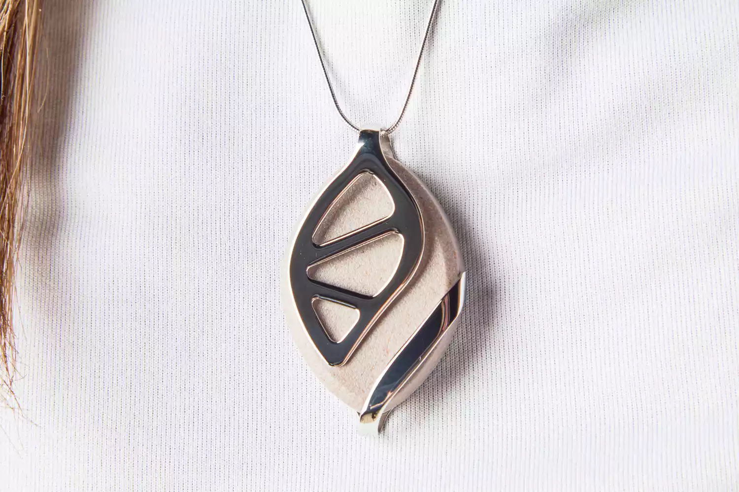 The Bellabeat Leaf Urban Smart Jewelry Health Tracker is worn as a necklace