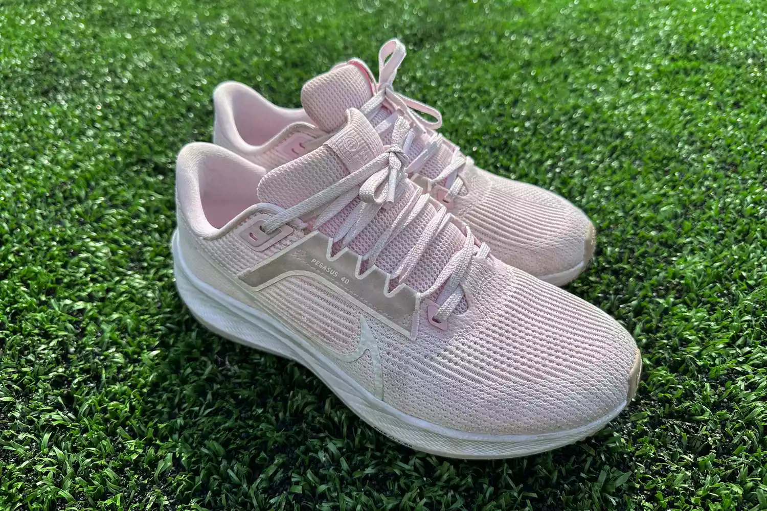 Nike Women's Pegasus 40 shoes displayed on grass