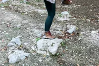 Person wearing Columbia Women’s Newton Ridge Plus Hiking Boots standing on a big rock