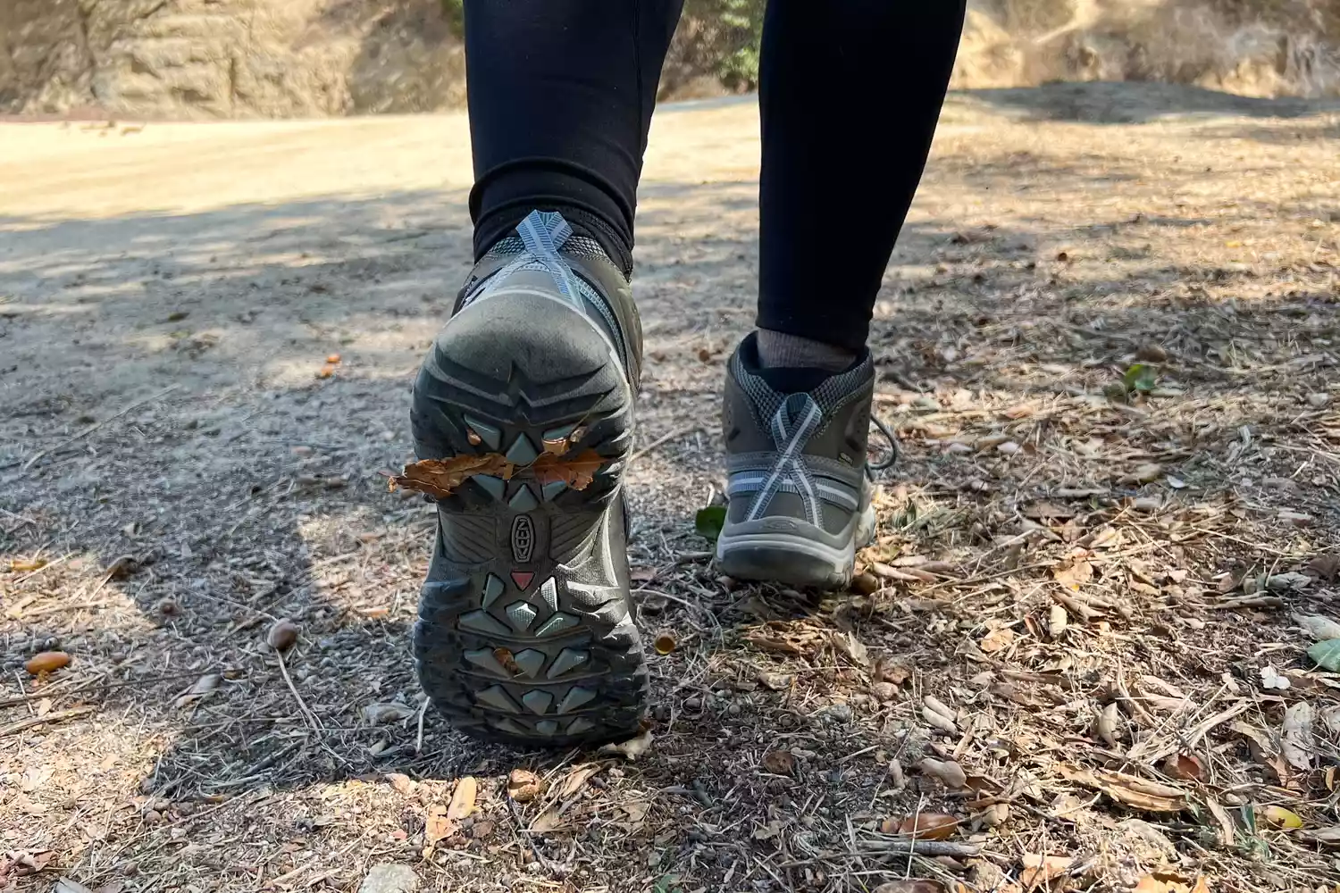 Person walking on a trail wearing KEEN Targhee III Mid Waterproof Hiking Boots