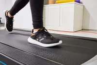 Person wearing Adidas Women's Cloudfoam Qt Racer Running Shoes on a treadmill