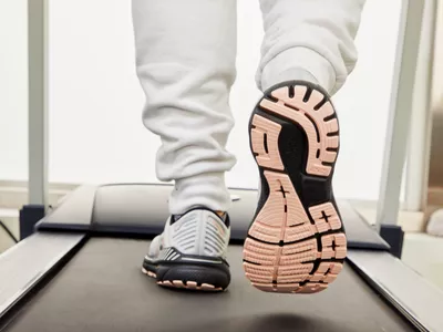 Closeup of the sole of a Brooks Adrenaline GTS 22 running shoe while a person walks on a treadmill