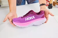Hands holding a pink Hoka Women's Bondi 8 sneaker 