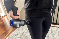 A person uses the Bob and Brad C2 Massage Gun on their hip