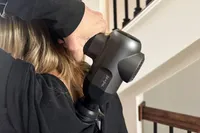 A person uses the Bob and Brad C2 Massage Gun on their back