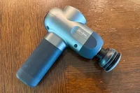 The Bob and Brad C2 Massage Gun on a wooden table